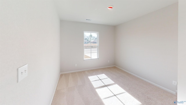 spare room featuring light colored carpet