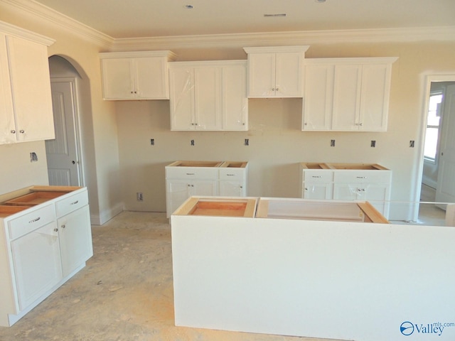 kitchen featuring crown molding, a center island, and white cabinets