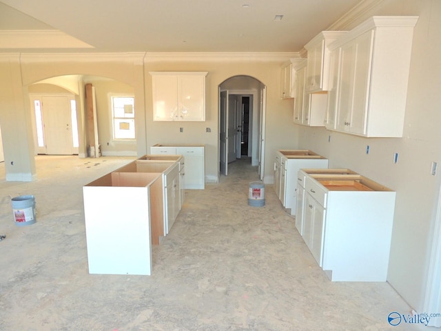 kitchen featuring white cabinetry, a kitchen island, and crown molding