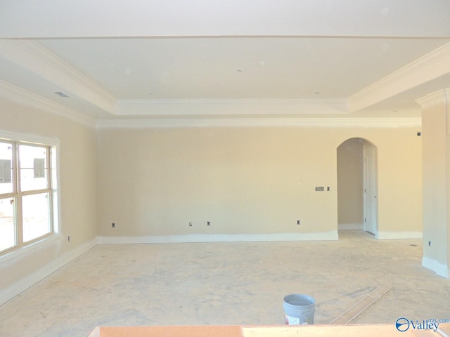 empty room featuring ornamental molding and a tray ceiling