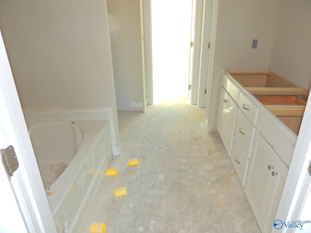 bathroom with concrete flooring and a bathing tub