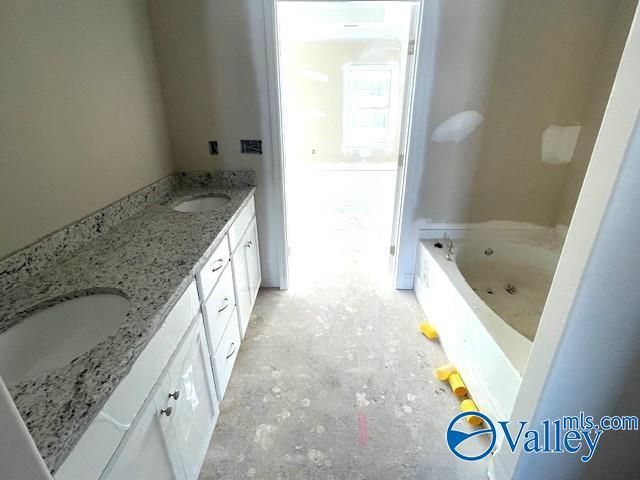 bathroom with vanity and a tub to relax in