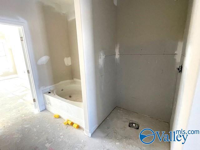 bathroom featuring concrete flooring and a bathing tub