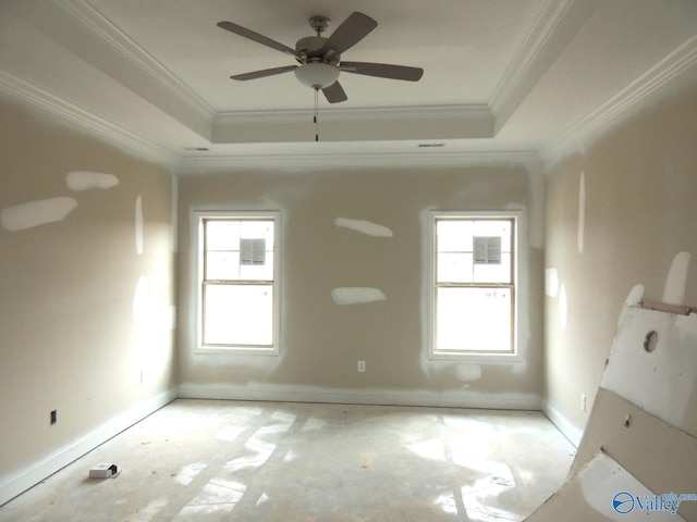 unfurnished room with crown molding, ceiling fan, a tray ceiling, and a healthy amount of sunlight