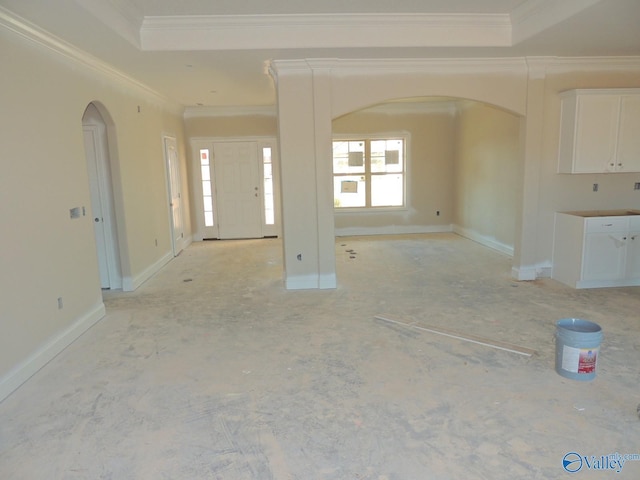 unfurnished living room featuring ornamental molding and a tray ceiling