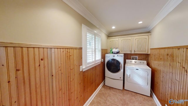 laundry room with separate washer and dryer, crown molding, cabinets, and wood walls