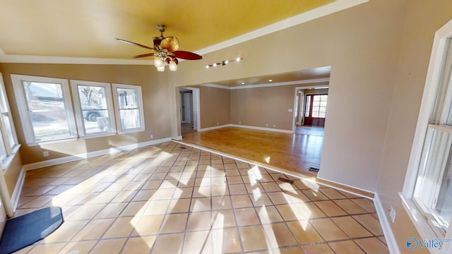 unfurnished room featuring crown molding, plenty of natural light, light tile patterned flooring, and ceiling fan