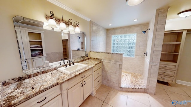 bathroom featuring a tile shower, tile patterned flooring, vanity, and ornamental molding