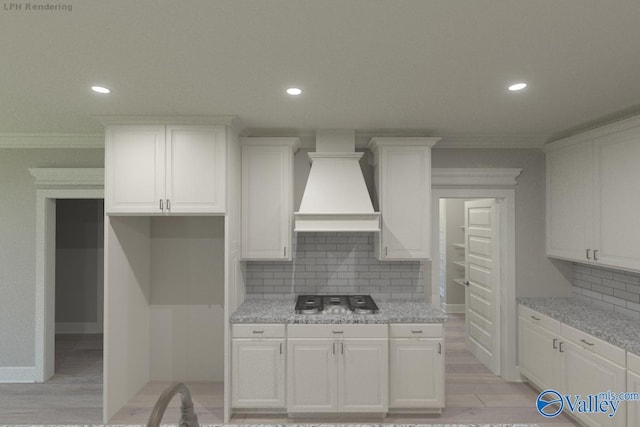 kitchen with premium range hood, decorative backsplash, light stone countertops, ornamental molding, and white cabinets