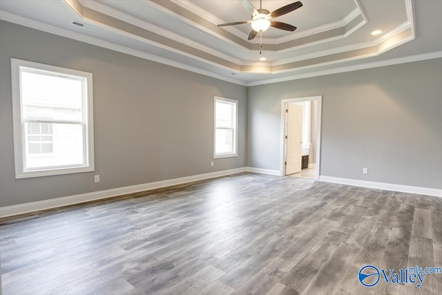 unfurnished room featuring ceiling fan, crown molding, wood-type flooring, and a tray ceiling