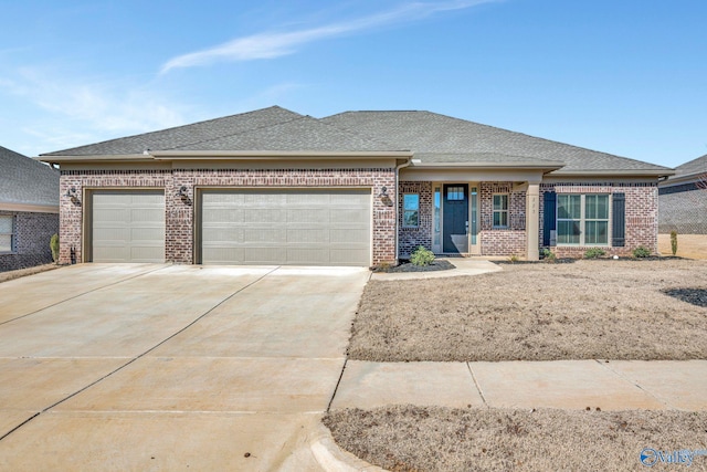 prairie-style house featuring a garage, concrete driveway, brick siding, and a shingled roof