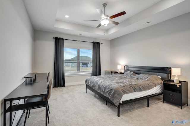 bedroom featuring a raised ceiling, visible vents, light carpet, ceiling fan, and baseboards