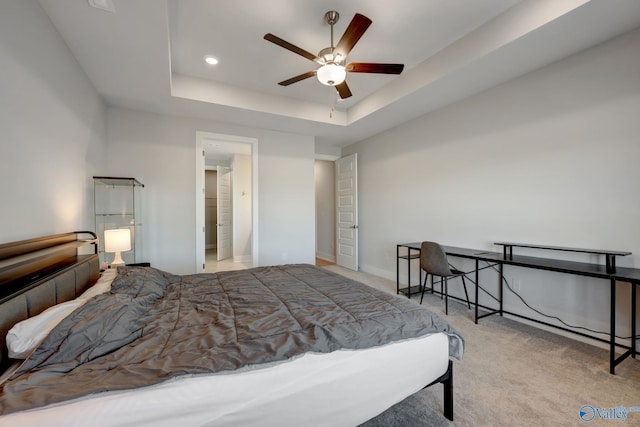 bedroom featuring ceiling fan, a tray ceiling, and carpet flooring