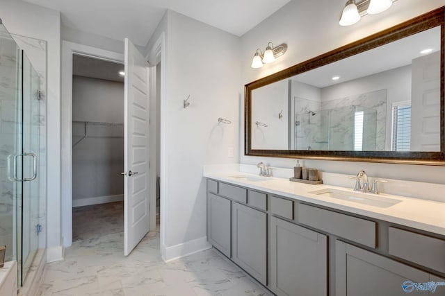 full bath featuring marble finish floor, a sink, a marble finish shower, and baseboards