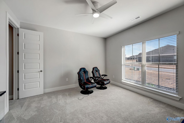 living area with a ceiling fan, baseboards, visible vents, and carpet flooring