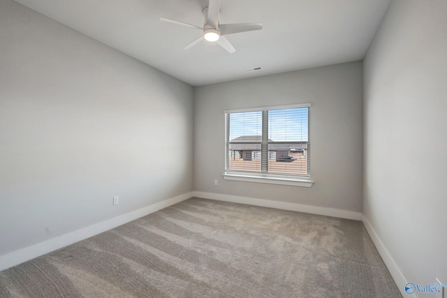 carpeted empty room featuring baseboards, visible vents, and ceiling fan