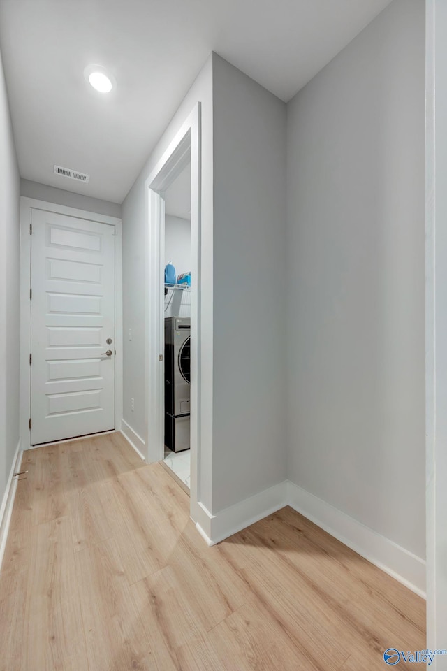 hallway featuring washer / clothes dryer, visible vents, light wood-style flooring, and baseboards