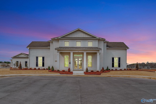 view of front of home with a standing seam roof, metal roof, and french doors