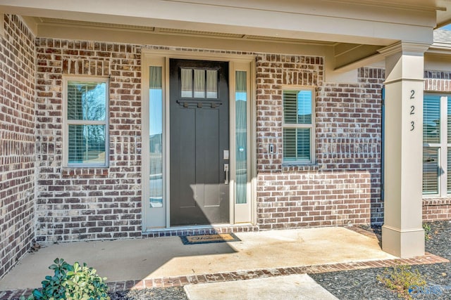 doorway to property featuring brick siding