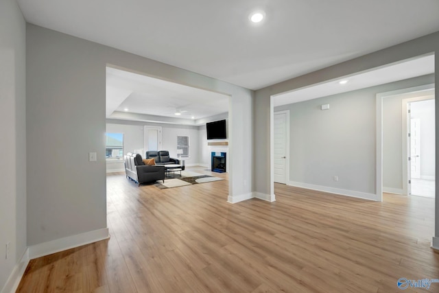 living area with recessed lighting, a fireplace, light wood-style flooring, and baseboards