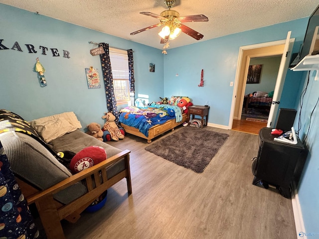 bedroom with hardwood / wood-style floors, a textured ceiling, and ceiling fan