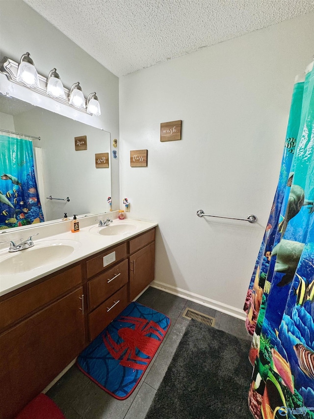 bathroom with vanity, tile patterned flooring, and a textured ceiling