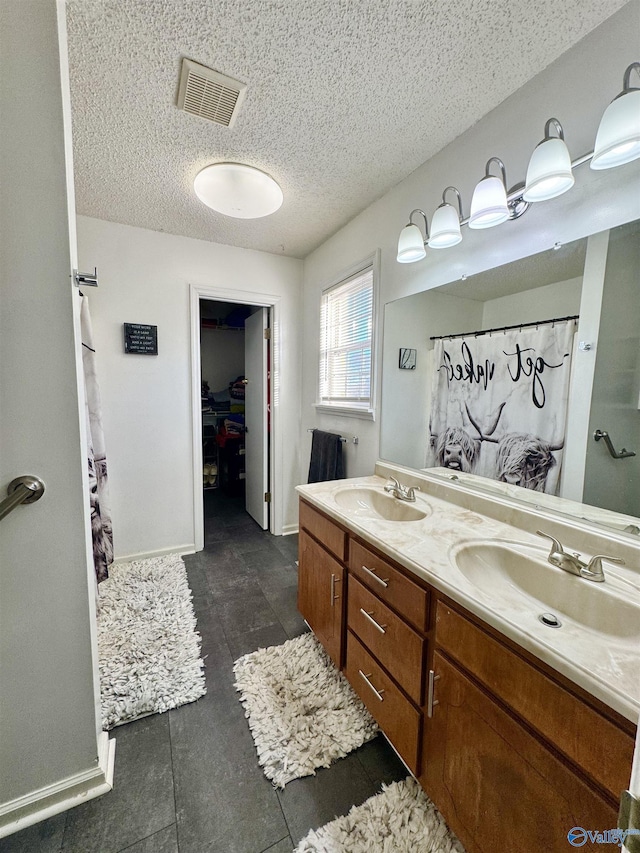 bathroom featuring vanity, a shower with curtain, and a textured ceiling