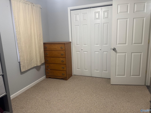 unfurnished bedroom featuring a closet, baseboards, and carpet flooring