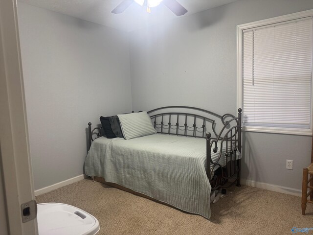 carpeted bedroom featuring ceiling fan and baseboards