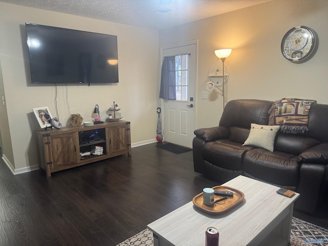 living room with a textured ceiling, wood finished floors, and baseboards