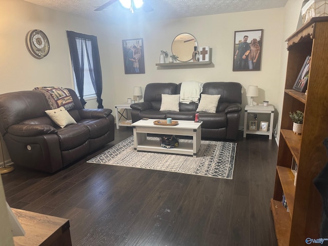 living area with ceiling fan, a textured ceiling, and wood finished floors