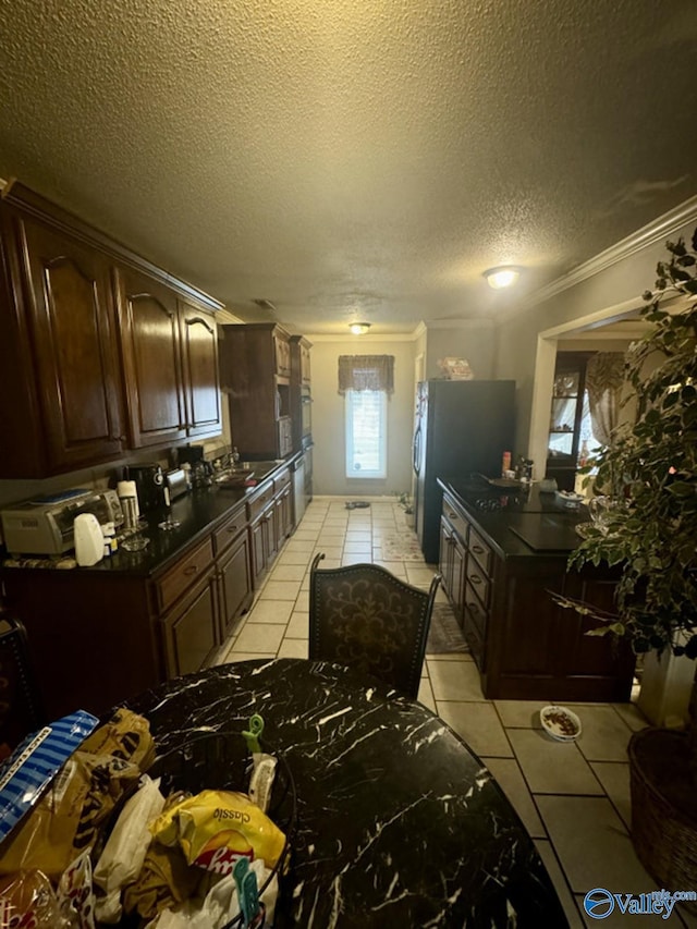 kitchen with light tile patterned floors, crown molding, and dark brown cabinetry