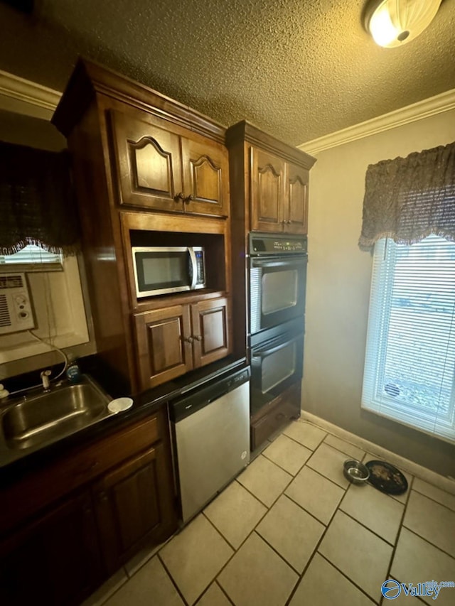 kitchen with sink, a textured ceiling, ornamental molding, light tile patterned floors, and appliances with stainless steel finishes