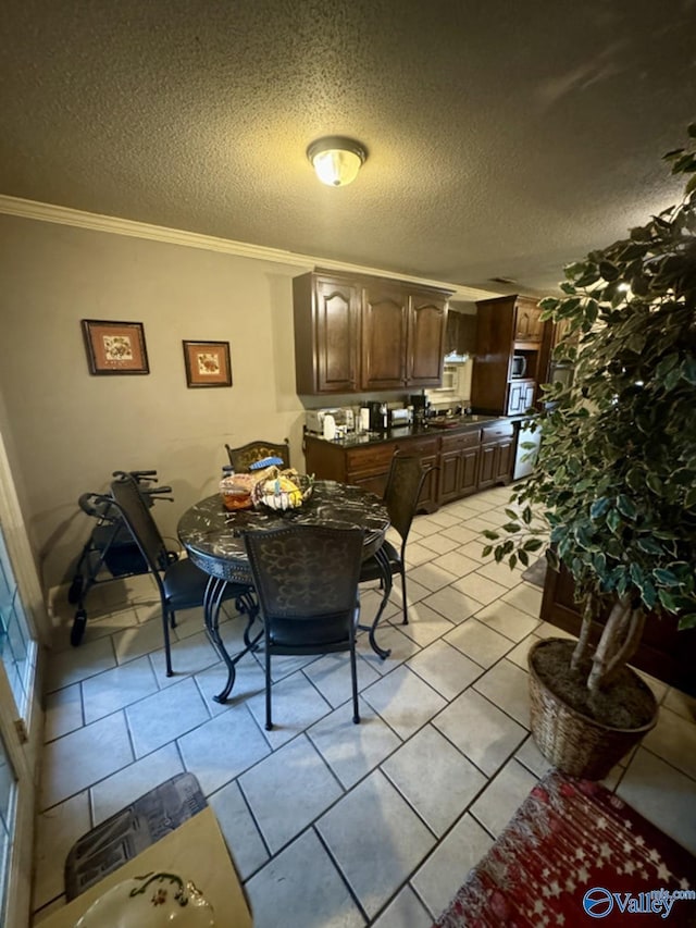 dining space featuring ornamental molding, a textured ceiling, and light tile patterned floors