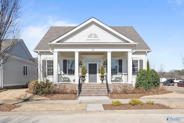 greek revival house with roof with shingles and a porch