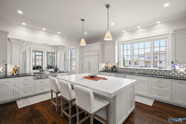 kitchen featuring a sink, stainless steel appliances, dark wood-type flooring, and a kitchen island