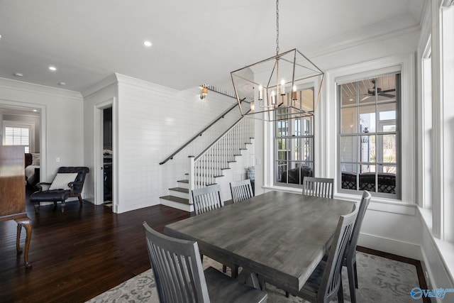 dining space featuring stairway, wood finished floors, baseboards, ornamental molding, and a chandelier