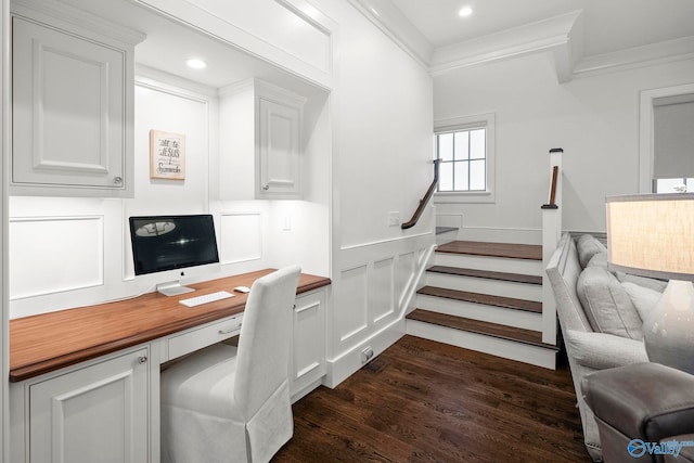 office with ornamental molding, built in desk, recessed lighting, a decorative wall, and dark wood-style flooring