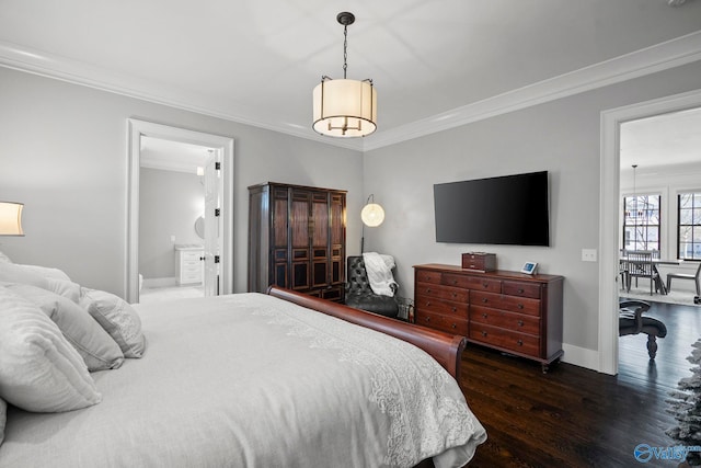 bedroom with ensuite bath, wood finished floors, baseboards, and ornamental molding