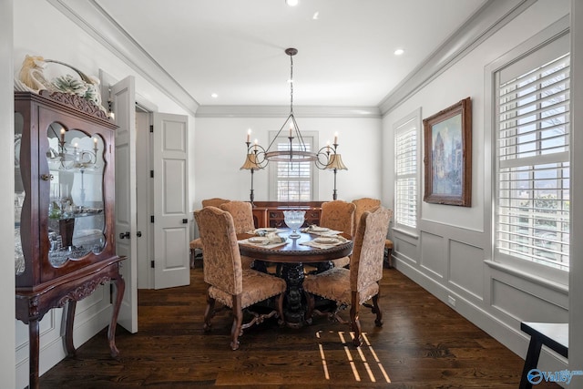 dining room featuring a notable chandelier, dark wood-style floors, recessed lighting, crown molding, and a decorative wall