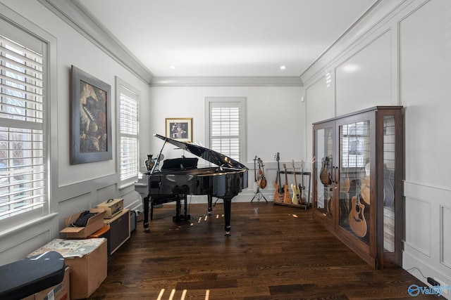 living area featuring crown molding, a decorative wall, wood finished floors, and a wainscoted wall