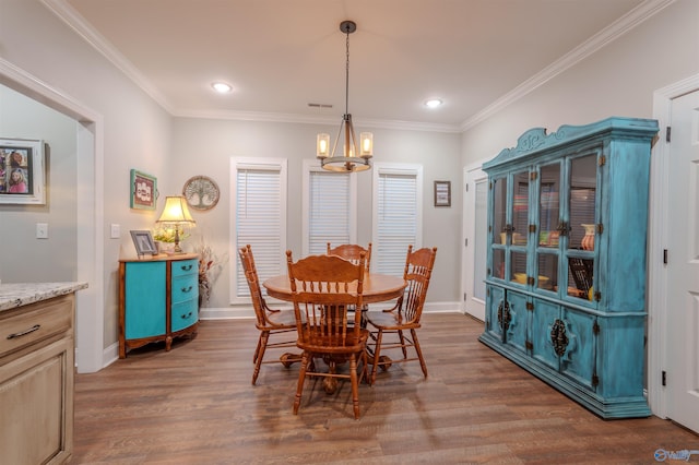 dining room with a notable chandelier, dark wood-type flooring, and ornamental molding