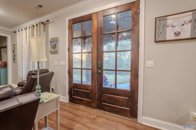 interior space with crown molding, light hardwood / wood-style floors, and french doors