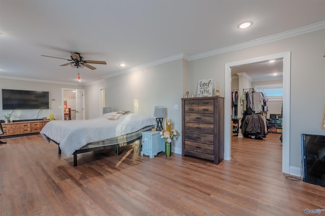 bedroom with crown molding, hardwood / wood-style flooring, and ceiling fan