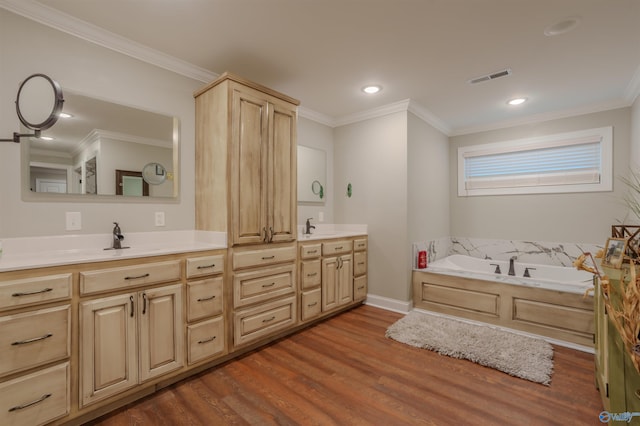 bathroom with wood-type flooring, a bath, vanity, and crown molding