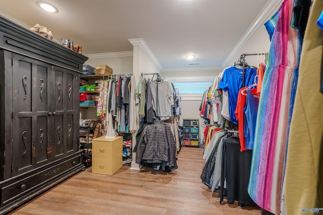 walk in closet with light hardwood / wood-style flooring