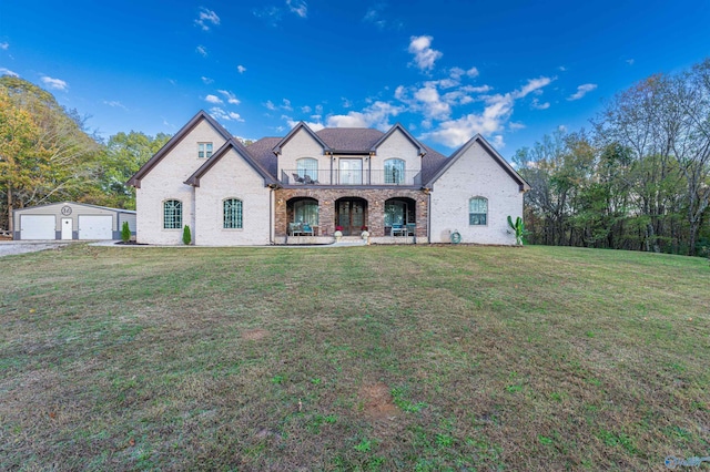 french provincial home with a porch, a garage, a balcony, an outbuilding, and a front yard