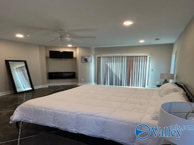 bedroom featuring ceiling fan and a fireplace