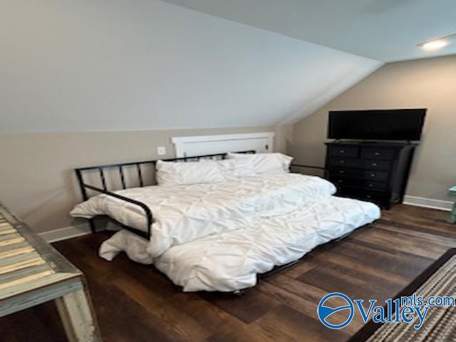 bedroom with lofted ceiling and dark wood-type flooring