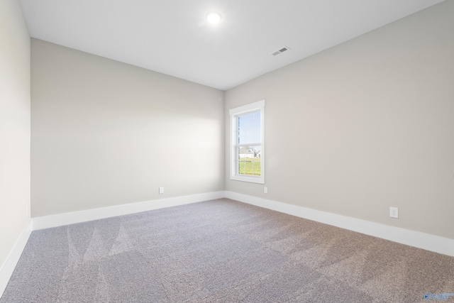 spare room with visible vents, carpet floors, and baseboards
